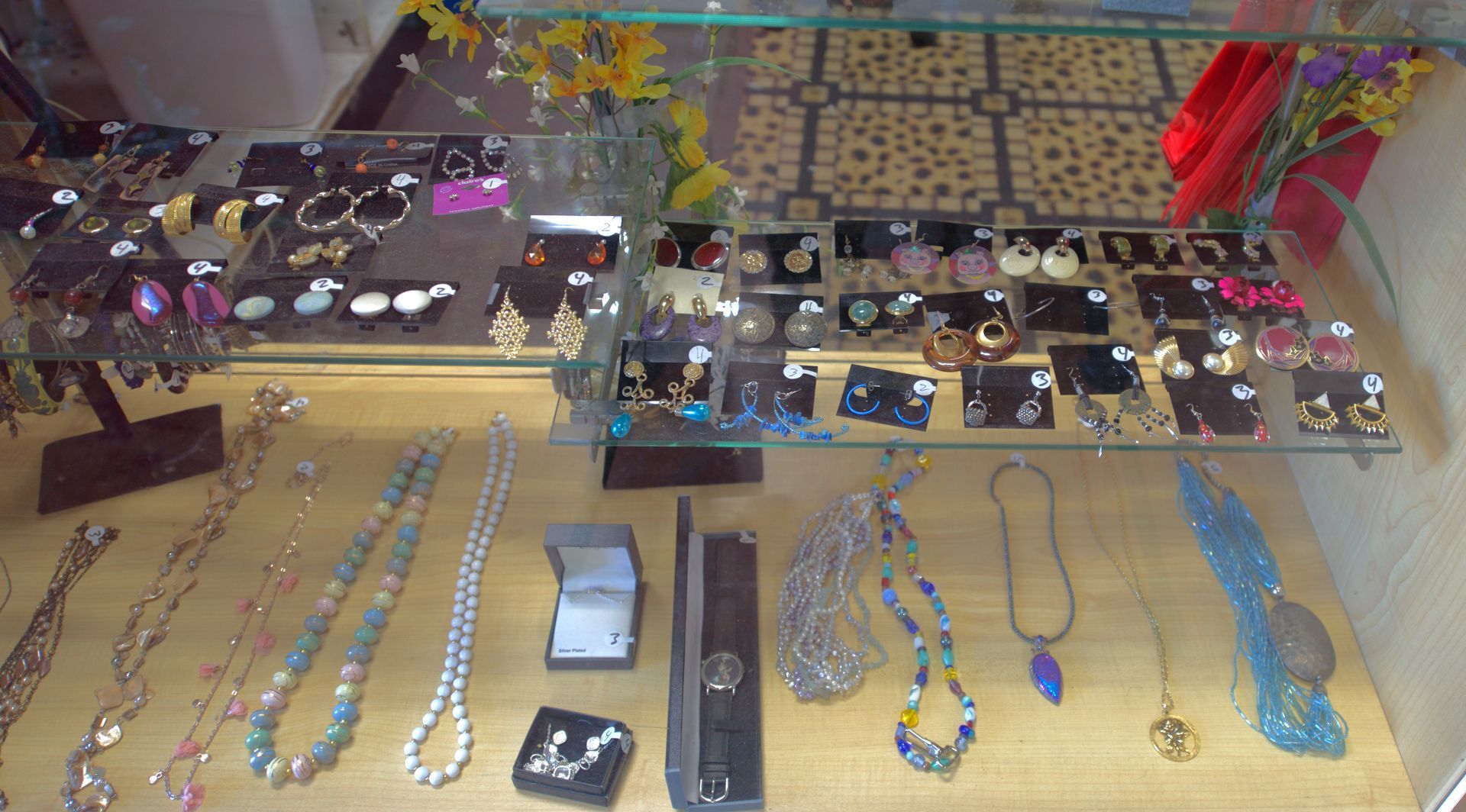 A display case filled with lots of jewelry including necklaces and earrings